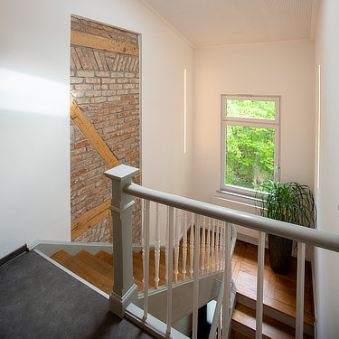 Treppenhaus mit Blick auf altes Mauerwerk