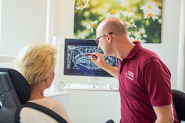 Zahnärztin erklärt einer Patientin das Röntgenbild