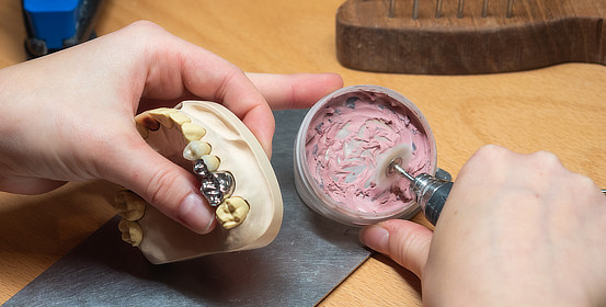 eine Labormitarbeiterin bearbeiten eine Prothese