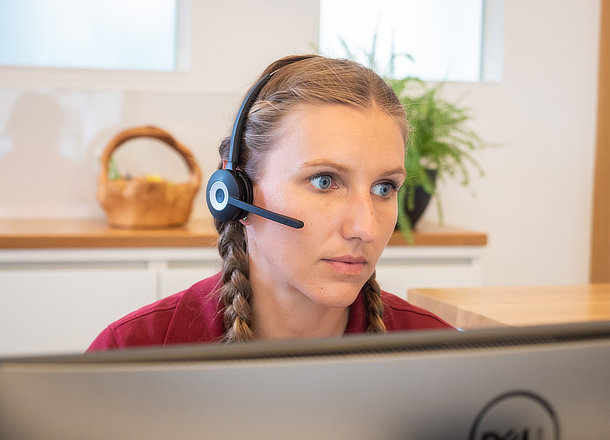 Dame mit Headset am Empfang